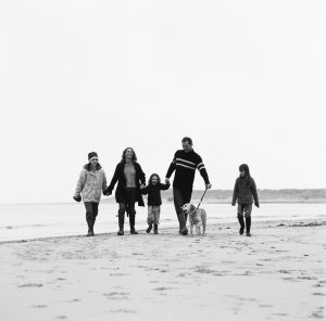 Couple Walking on the Beach with Their Three Daughters and Dog